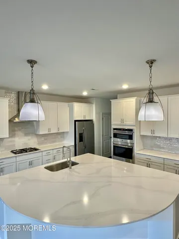 a kitchen with stainless steel appliances a sink a stove a microwave and cabinets