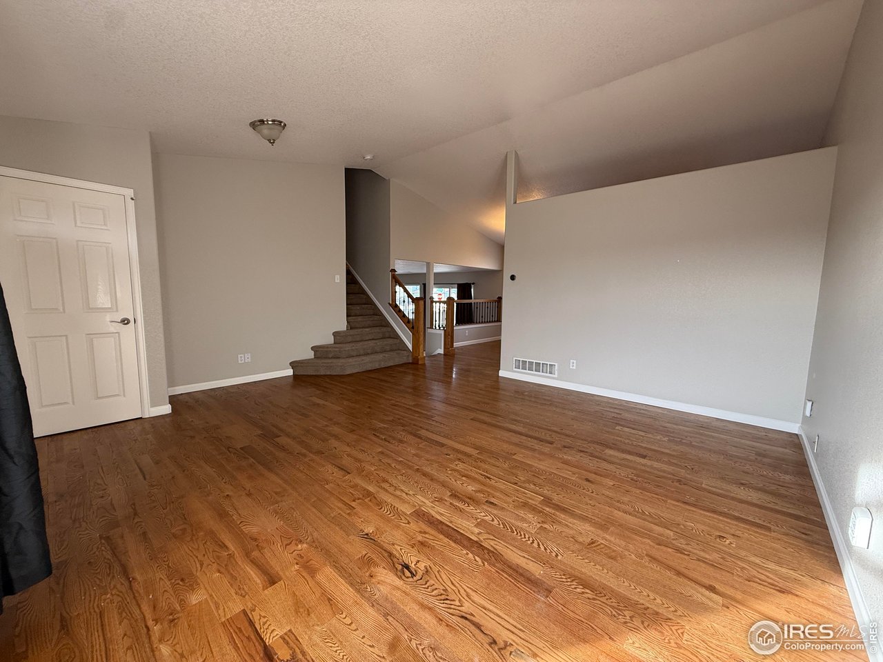 613 Sumac Street Frederick, CO 80530 - Photo 19 of 34 a view of an empty room with stairs and a wooden floor