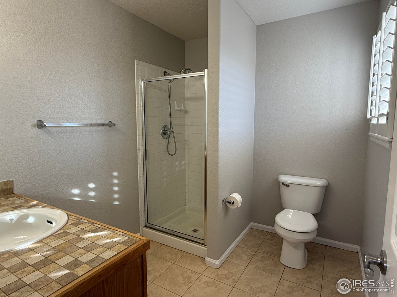 613 Sumac Street Frederick, CO 80530 - Photo 23 of 34 a bathroom with a granite countertop toilet a sink and shower