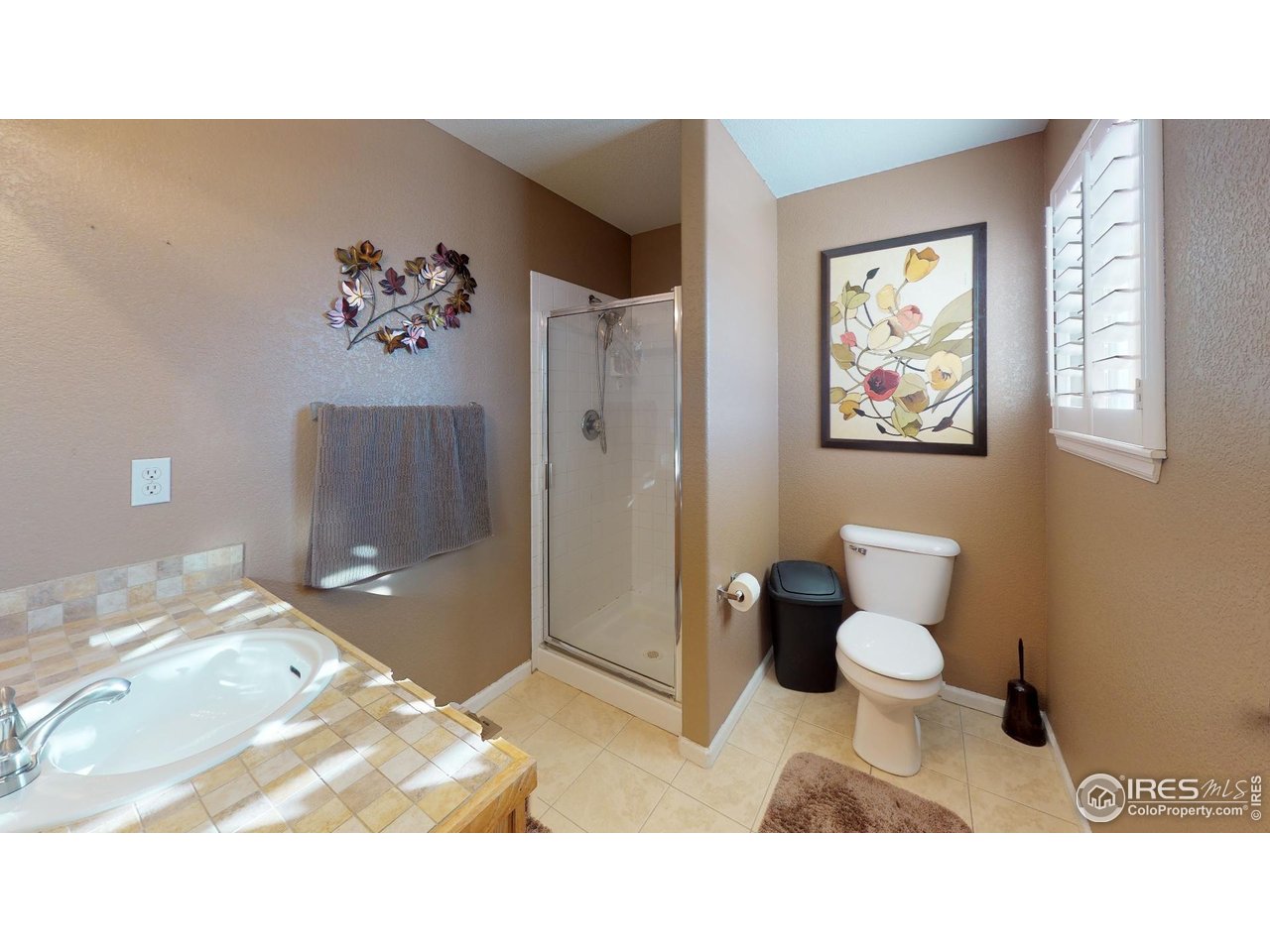 613 Sumac Street Frederick, CO 80530 - Photo 26 of 34 a bathroom with a toilet a sink and glass door