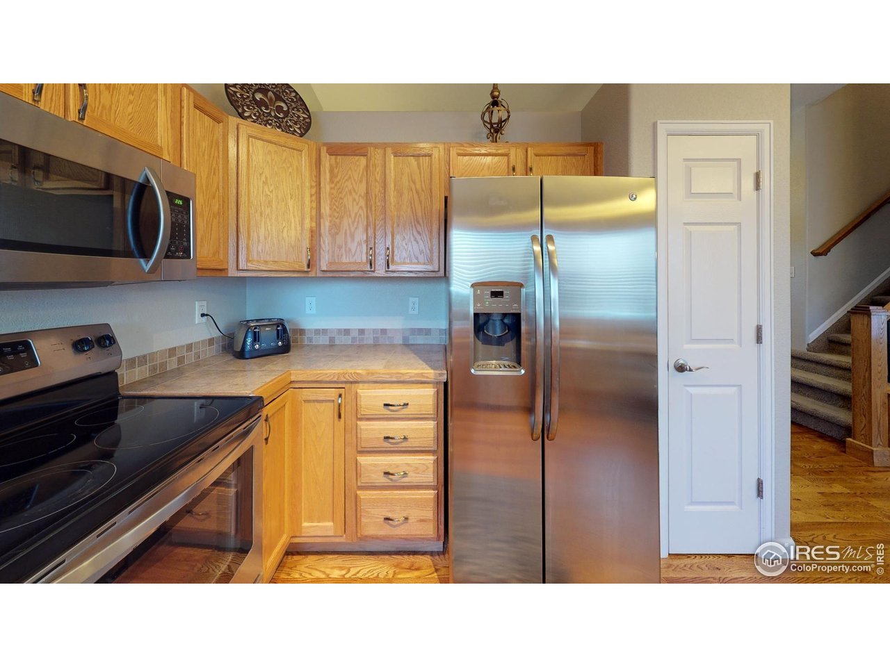 613 Sumac Street Frederick, CO 80530 - Photo 29 of 34 a kitchen with stainless steel appliances a refrigerator and a stove