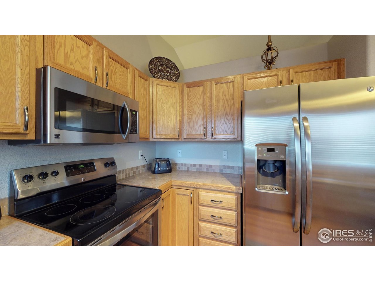 613 Sumac Street Frederick, CO 80530 - Photo 32 of 34 a kitchen with a refrigerator and a stove top oven