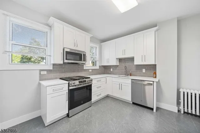a kitchen with granite countertop white cabinets and white stainless steel appliances