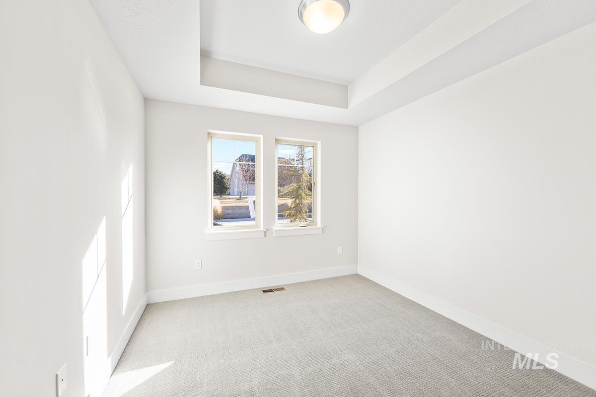 6983 South Skybreak Lane Meridian, ID 83642 - Photo 12 of 25 Unfurnished room featuring light colored carpet and a tray ceiling