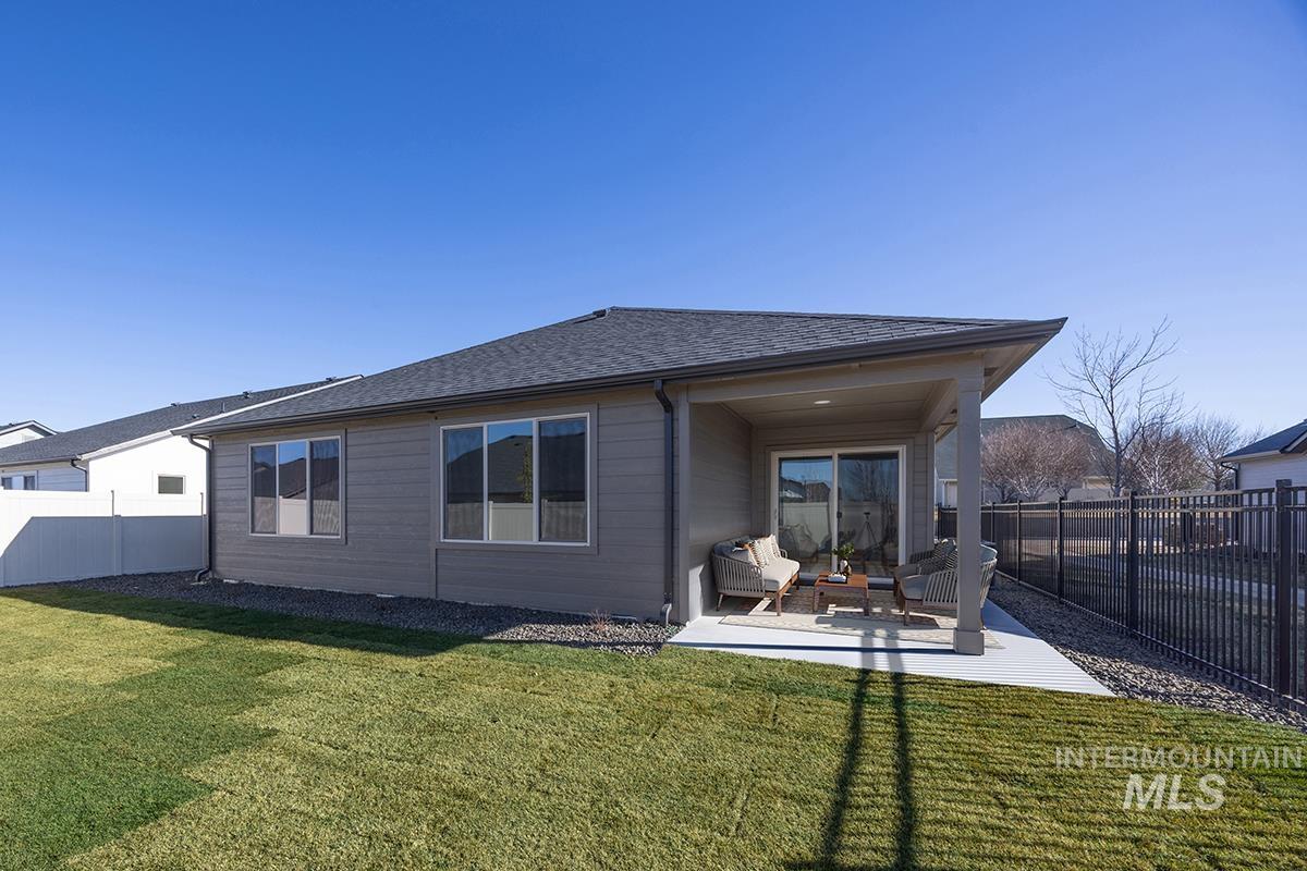 6983 South Skybreak Lane Meridian, ID 83642 - Photo 15 of 25 Rear view of house featuring a patio, a fenced backyard, and roof with shingles