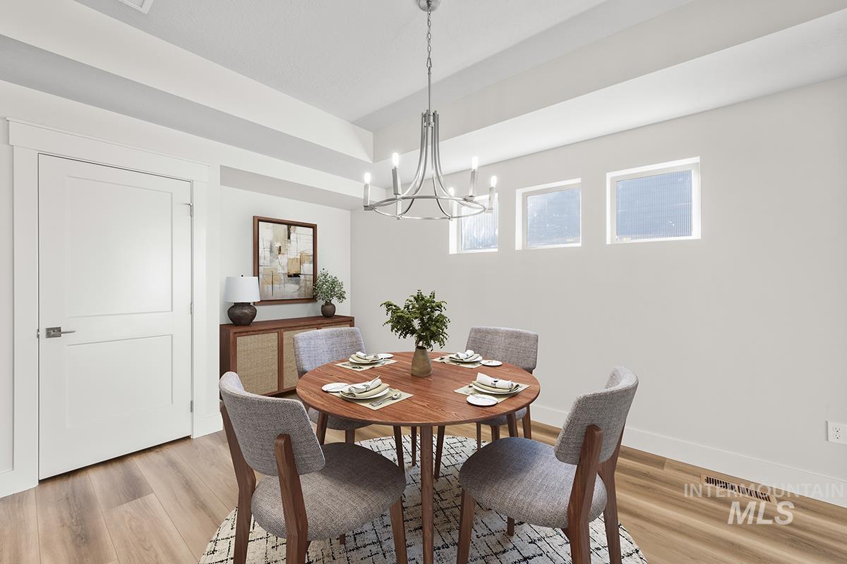 6983 South Skybreak Lane Meridian, ID 83642 - Photo 4 of 25 Dining space featuring hanging lights, light wood finished floors, and a tray ceiling