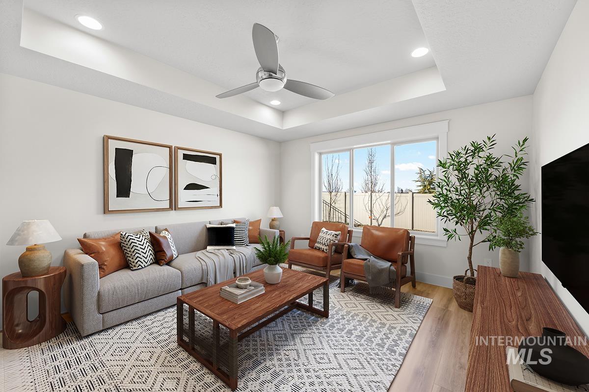 6983 South Skybreak Lane Meridian, ID 83642 - Photo 6 of 25 Living area featuring a raised ceiling, recessed lighting, ceiling fan, and light wood-style floors