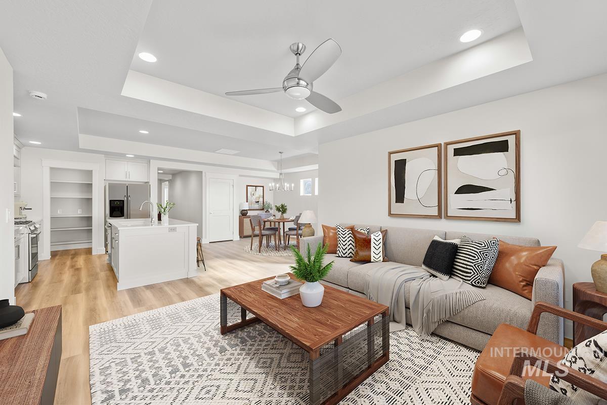 6983 South Skybreak Lane Meridian, ID 83642 - Photo 7 of 25 Living room featuring a ceiling fan, recessed lighting, light wood-style flooring, and a raised ceiling