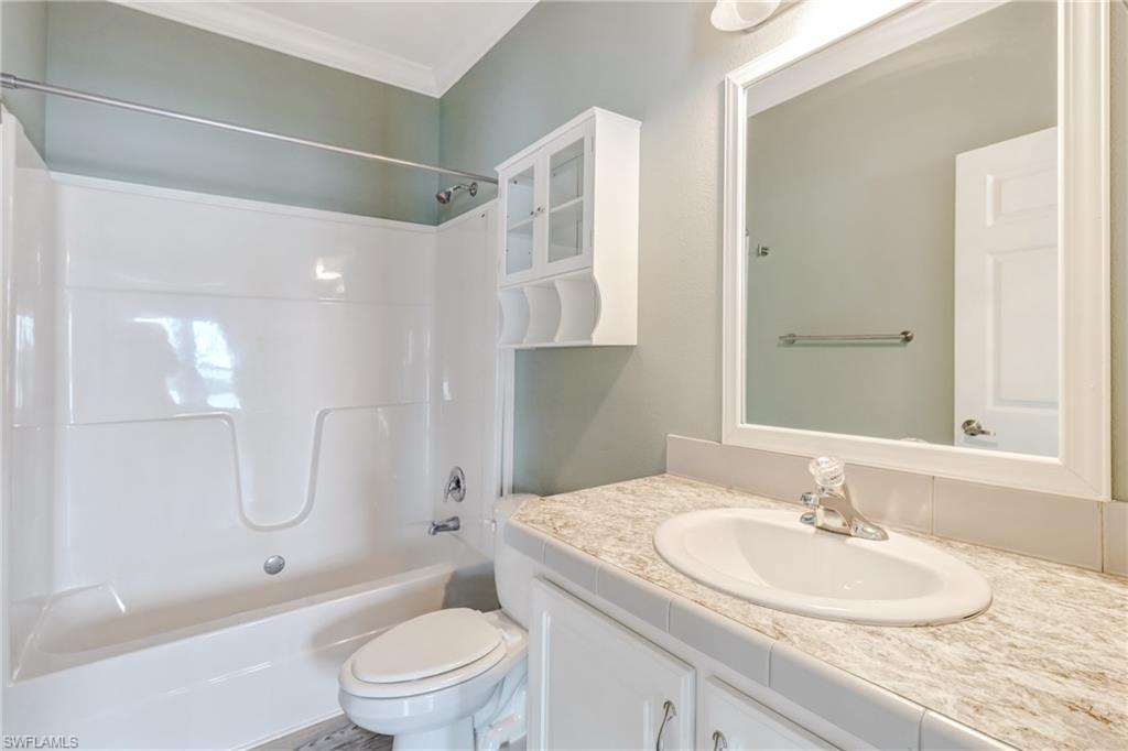 4835 East Riverside Drive Fort Myers, FL 33905 - Photo 27 of 35 a bathroom with a granite countertop sink a toilet and a large mirror