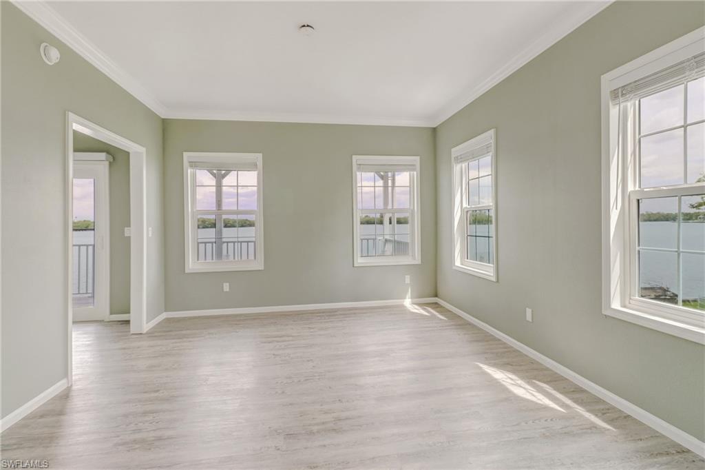 4835 East Riverside Drive Fort Myers, FL 33905 - Photo 30 of 35 an empty room with wooden floor and windows