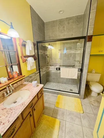 a bathroom with a granite countertop sink and a shower