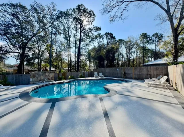a view of backyard with swimming pool and seating space