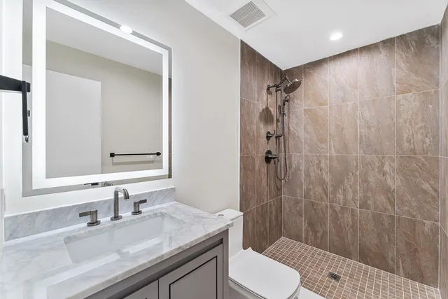 a bathroom with a sink a toilet and shower