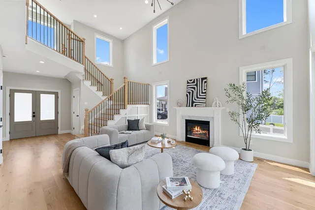 a living room with furniture a fireplace and a floor to ceiling window