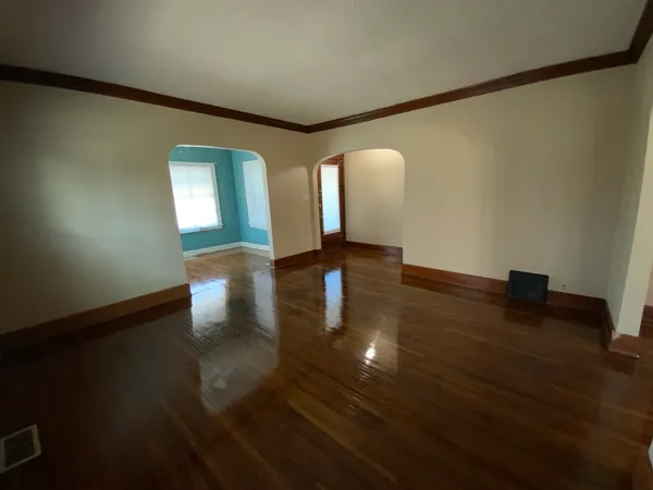 a view of empty room with wooden floor