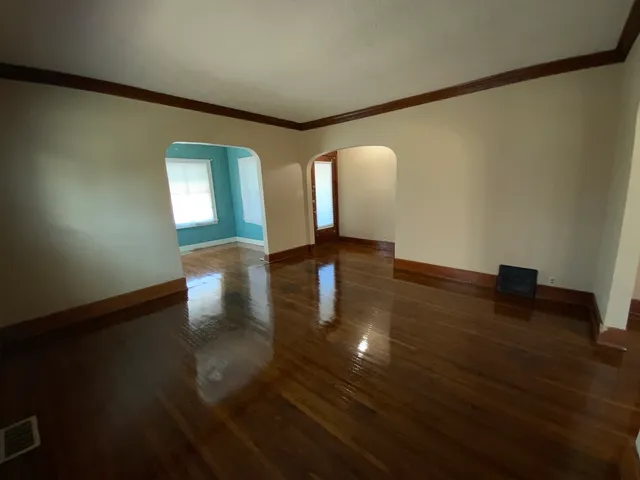 a view of empty room with wooden floor