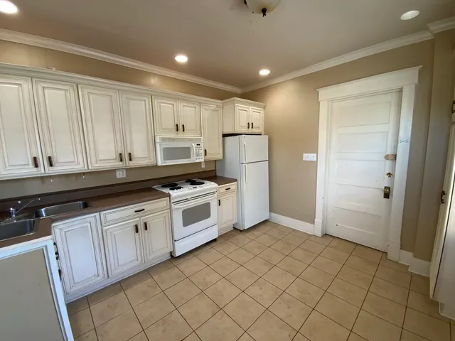 a kitchen with white cabinets and white appliances