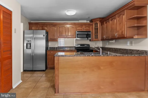 a kitchen with stainless steel appliances granite countertop a refrigerator a stove top oven a sink and dishwasher