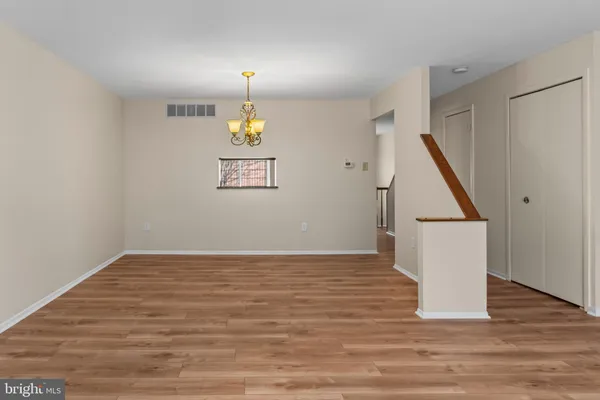 a view of empty room with wooden floor and window