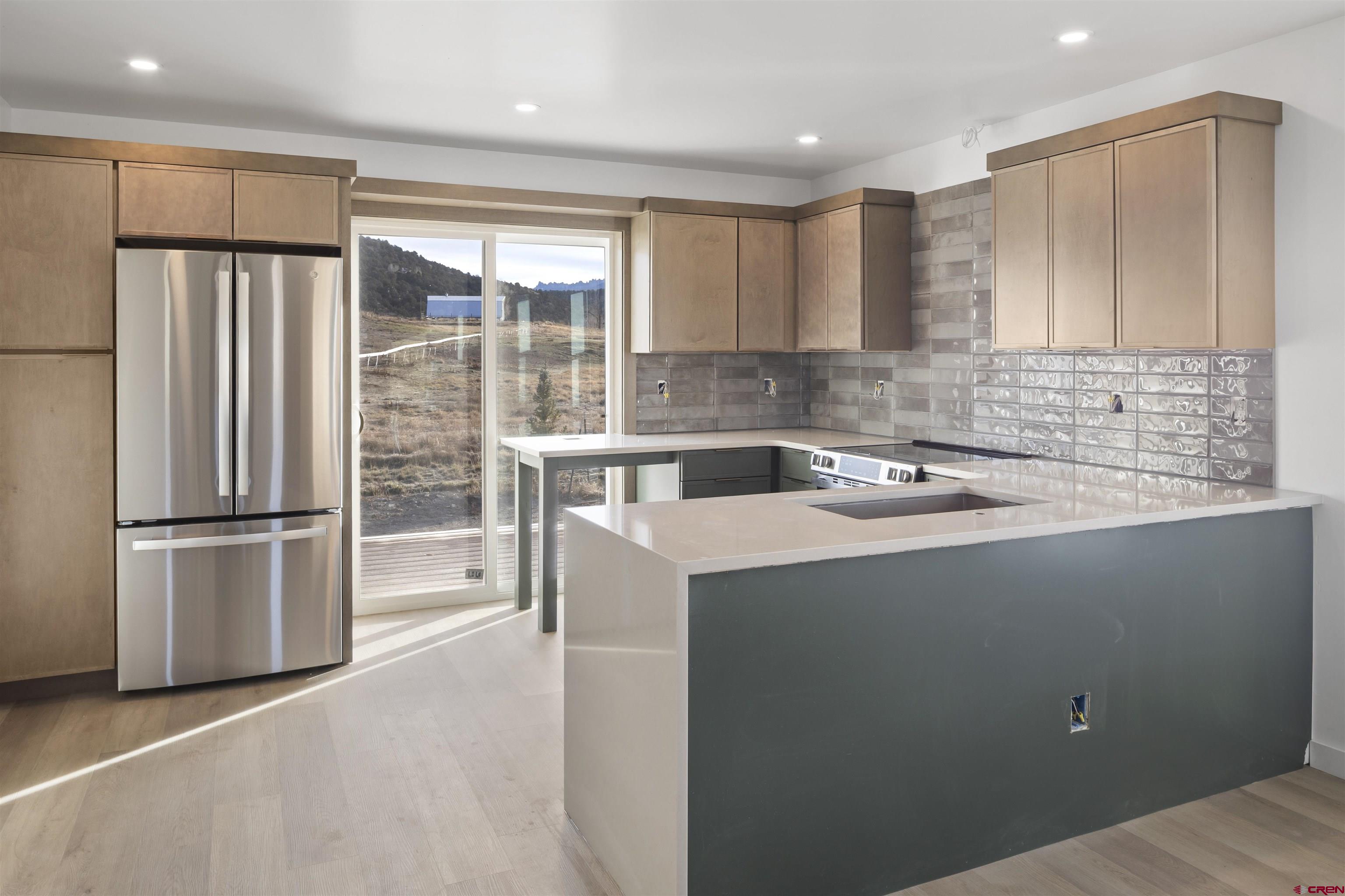 228 Redcliff Drive Ridgway, CO 81432 - Photo 5 of 35 a kitchen with a sink a refrigerator a washer and dryer