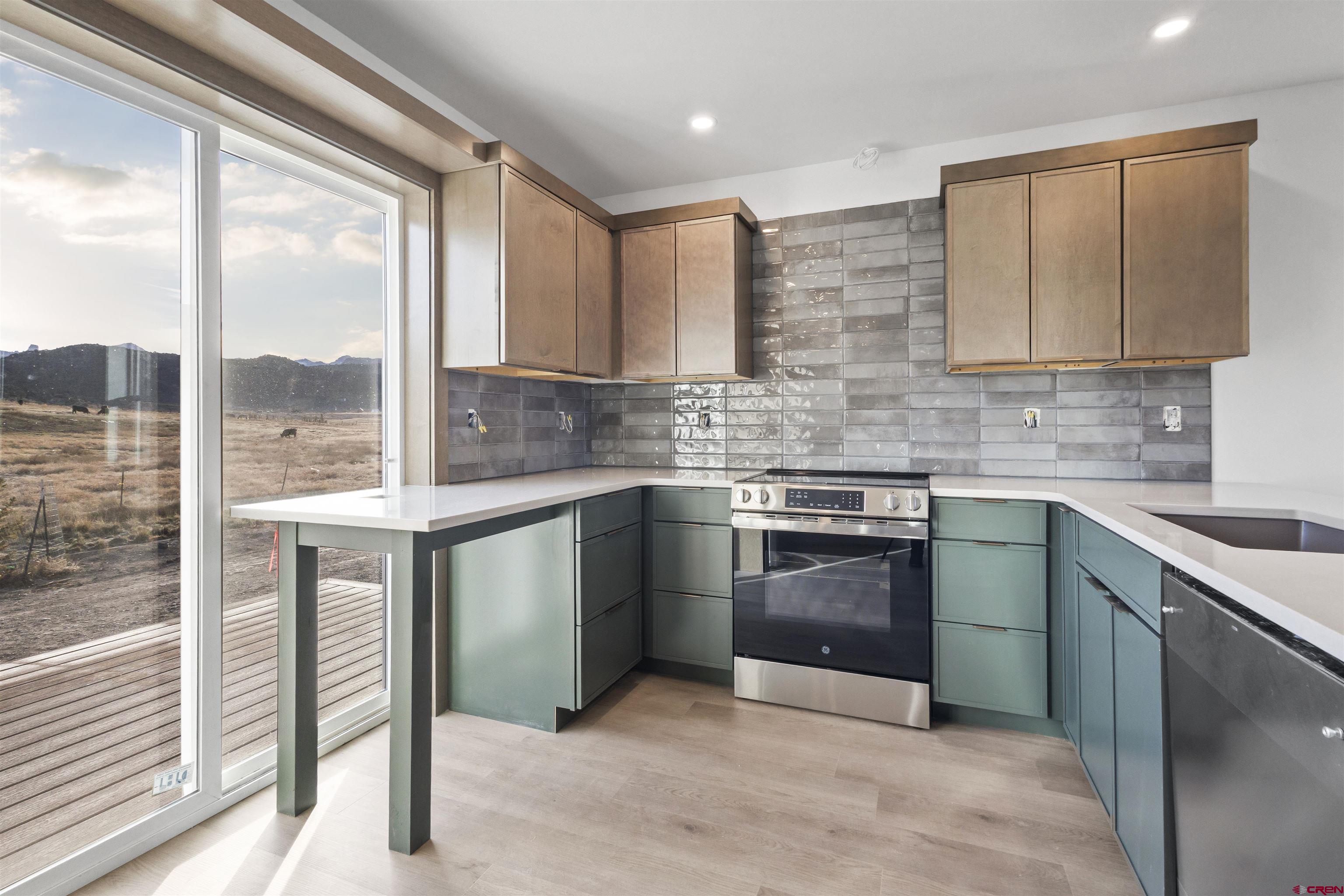 228 Redcliff Drive Ridgway, CO 81432 - Photo 7 of 35 a kitchen with stainless steel appliances granite countertop a stove sink and cabinets