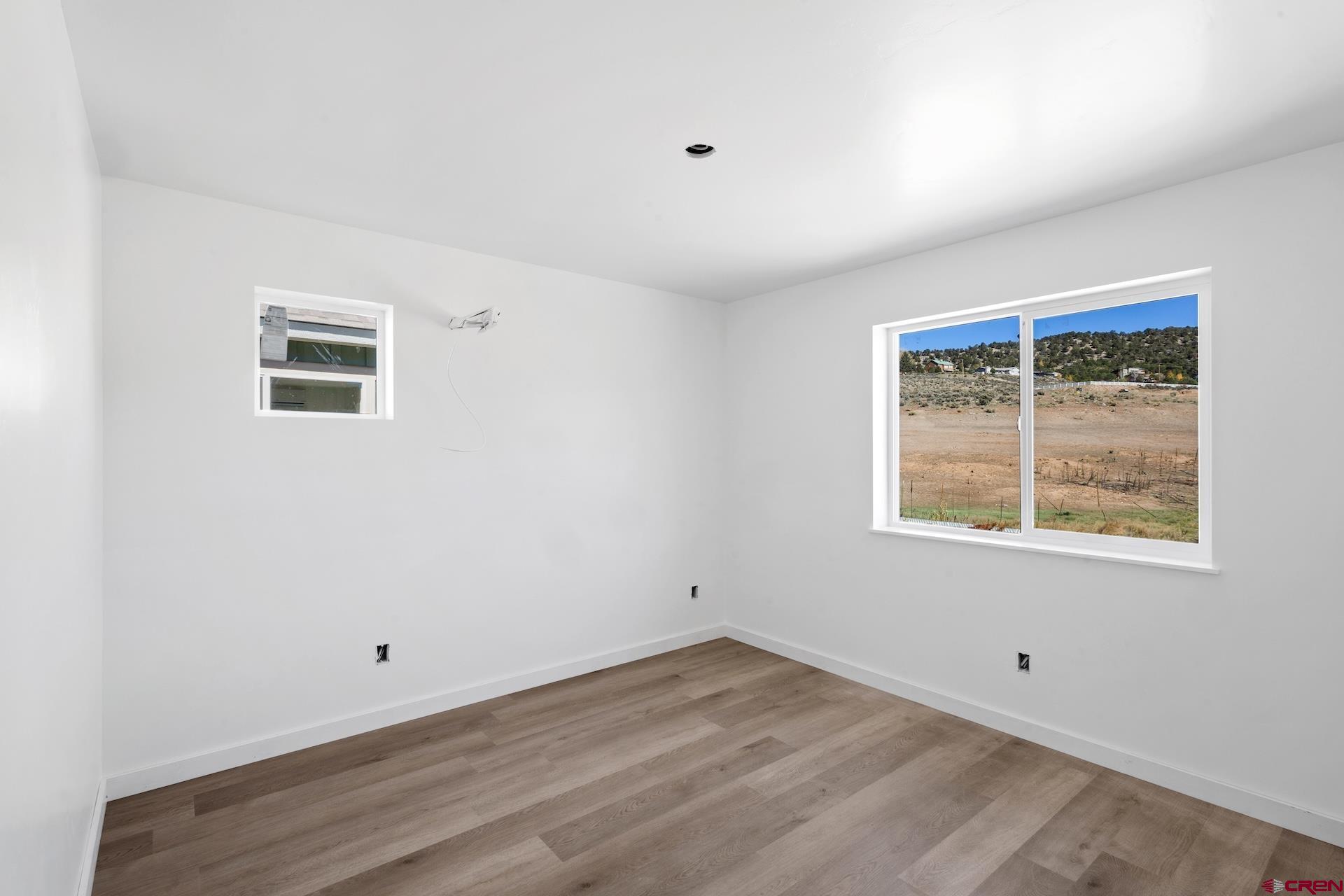 228 Redcliff Drive Ridgway, CO 81432 - Photo 9 of 35 an empty room with wooden floor and windows
