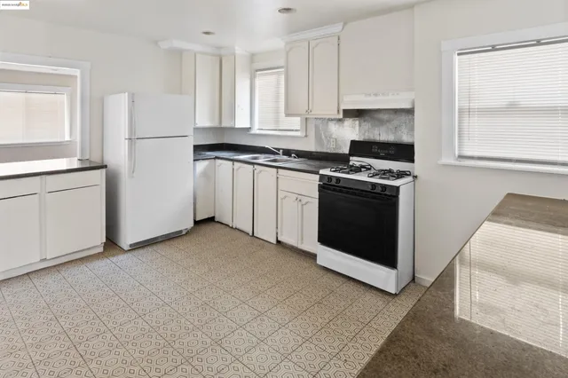 a kitchen with white cabinets and white appliances