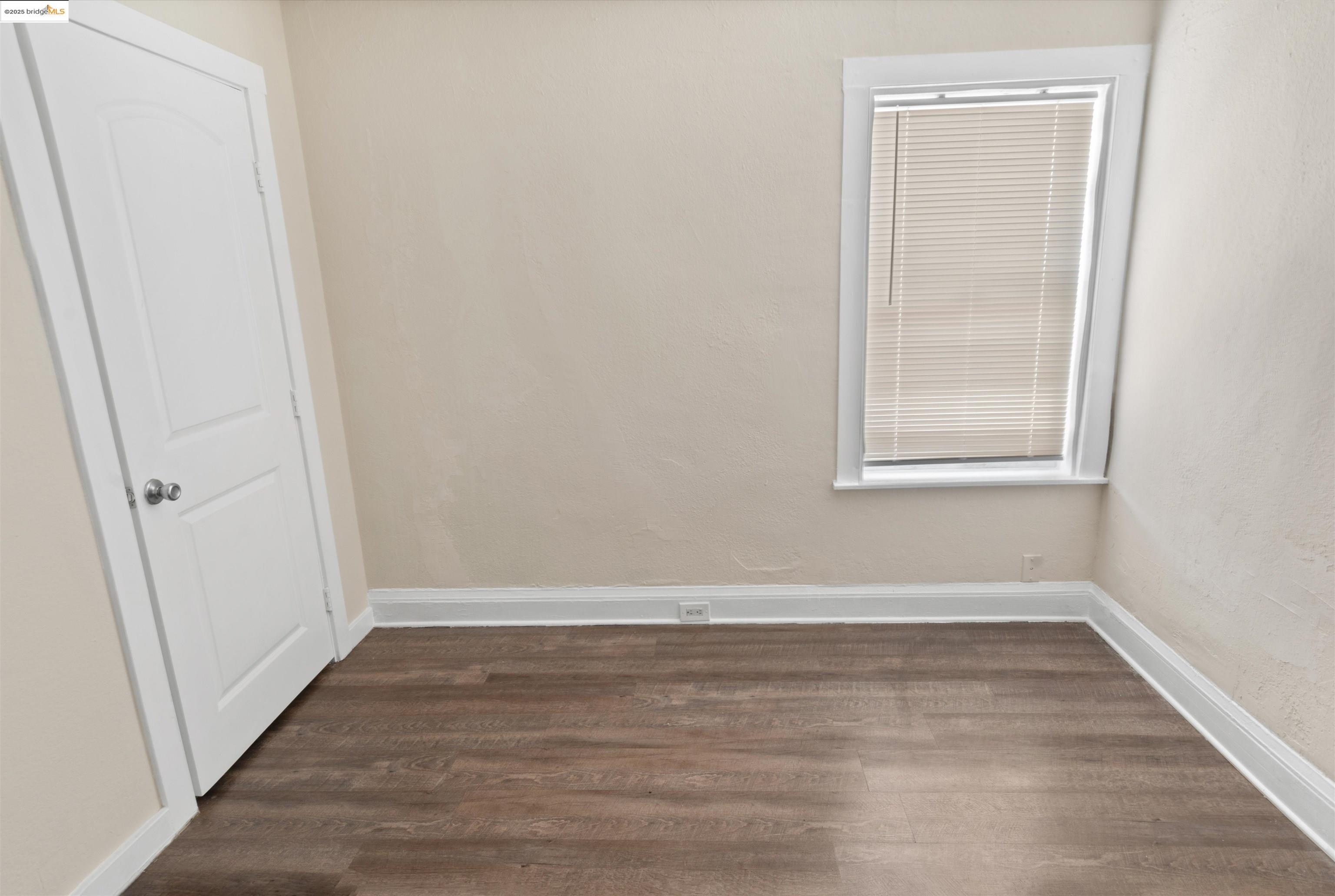 1285 77th Avenue Oakland, CA 94621 - Photo 5 of 8 a view of an empty room with wooden floor and a window
