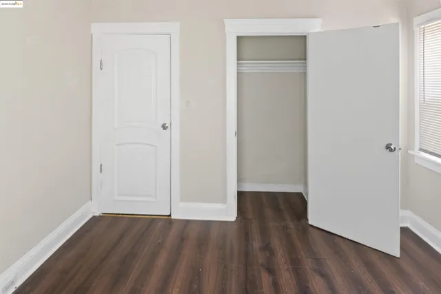an empty room with wooden floor and closet