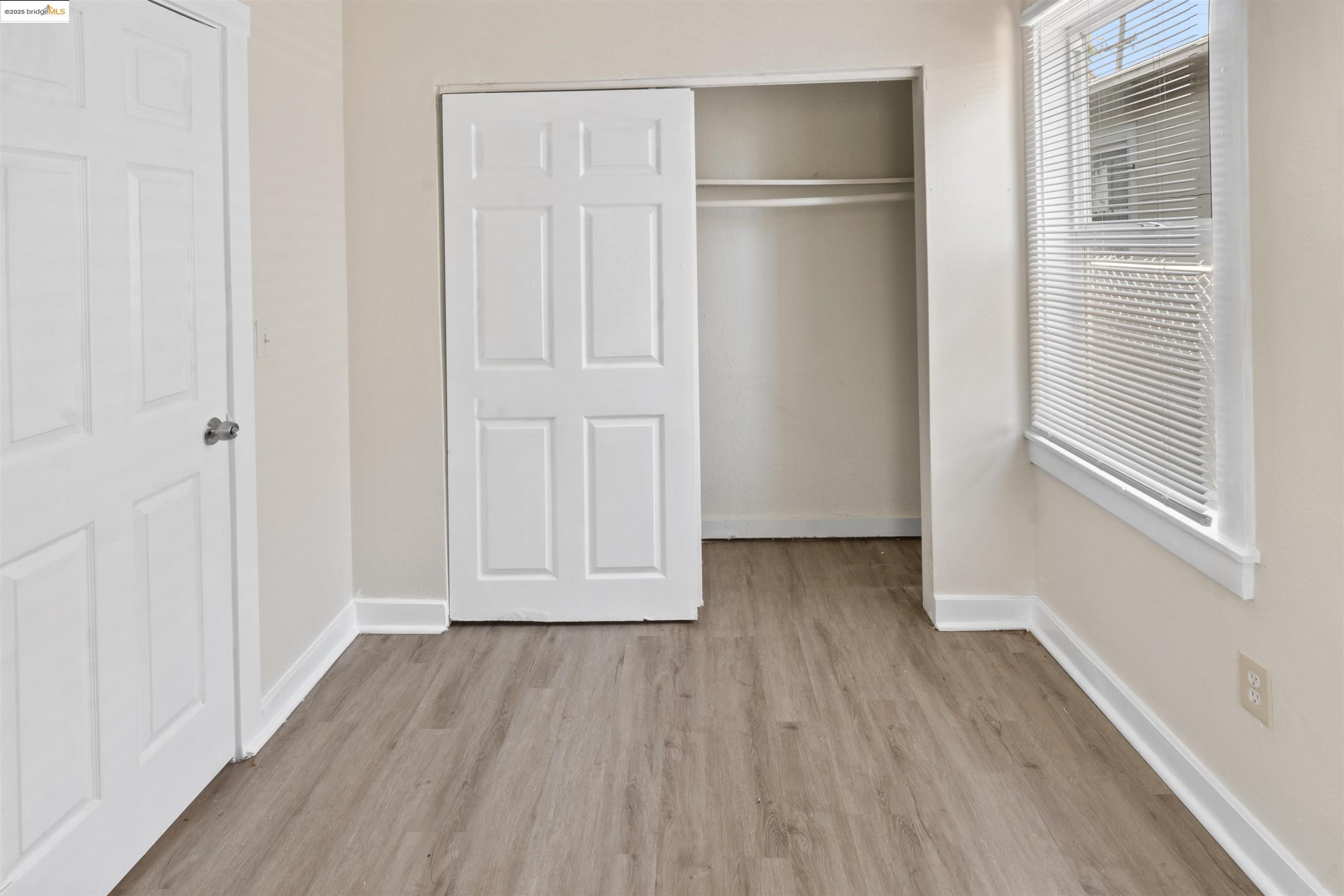 1285 77th Avenue Oakland, CA 94621 - Photo 7 of 8 a view of an empty room with wooden floor