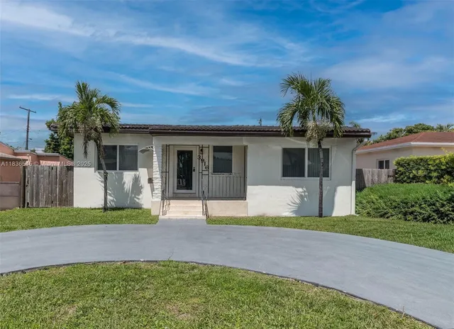 a front view of a house with a garden and yard
