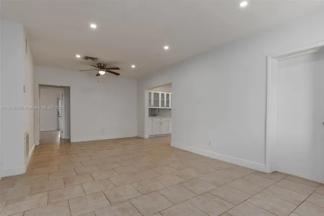 a kitchen with white cabinets and sink