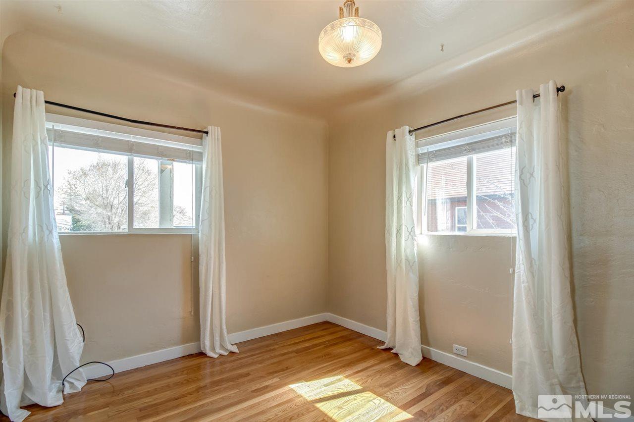 735 Plumas Street Reno, NV 89509 - Photo 8 of 25 an empty room with wooden floor cabinet and windows