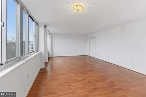 a view of a hallway with wooden floor and a large window