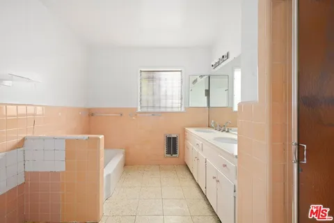 a bathroom with a double vanity sink a toilet and a tub