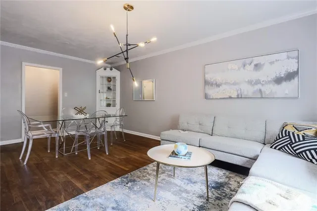 a living room with furniture a dining table and a chandelier