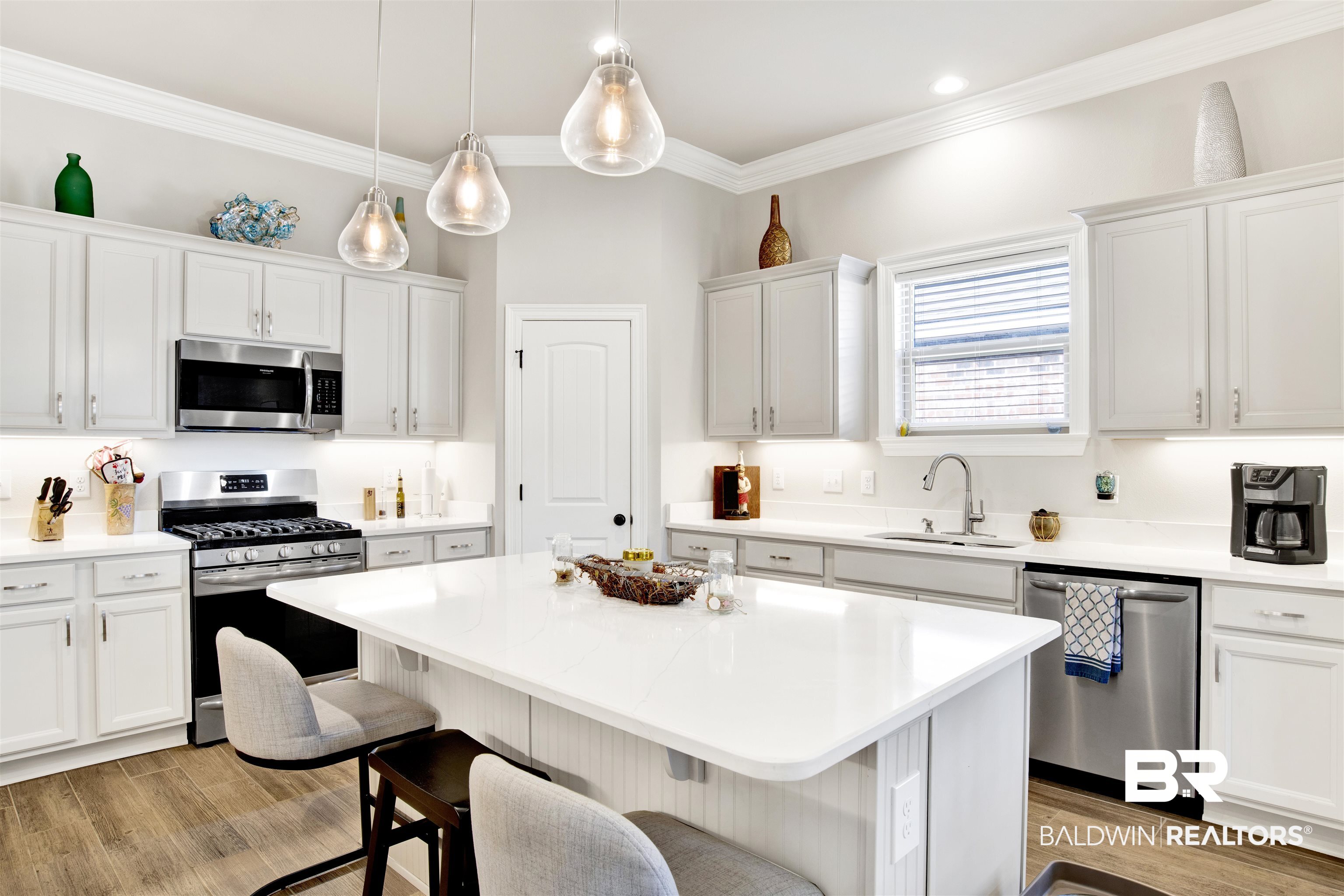 1406 Aldon Street Foley, AL 36535 - Photo 12 of 30 Kitchen featuring sink, stainless steel appliances, a kitchen island, light gray cabinets, and luxury wood-look tile flooring.