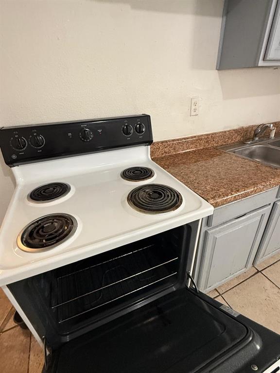 4115 Columbia Street Orlando, FL 32811 - Photo 9 of 16 a close view of kitchen stove with microwave and cabinets