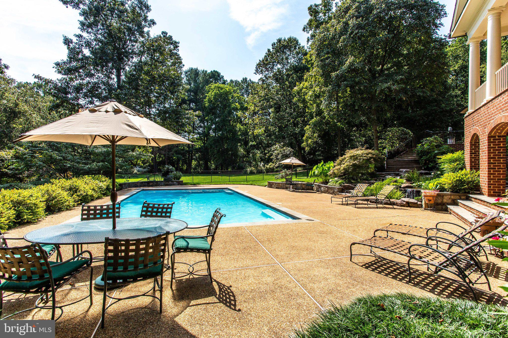 1008 Pine Hill Road McLean, VA 22101 - Photo 21 of 29 a view of swimming pool with lawn chairs under an umbrella