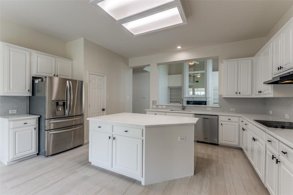 3313 Shady Valley Road Plano, TX 75025 - Photo 15 of 34 a kitchen with white cabinets and stainless steel appliances