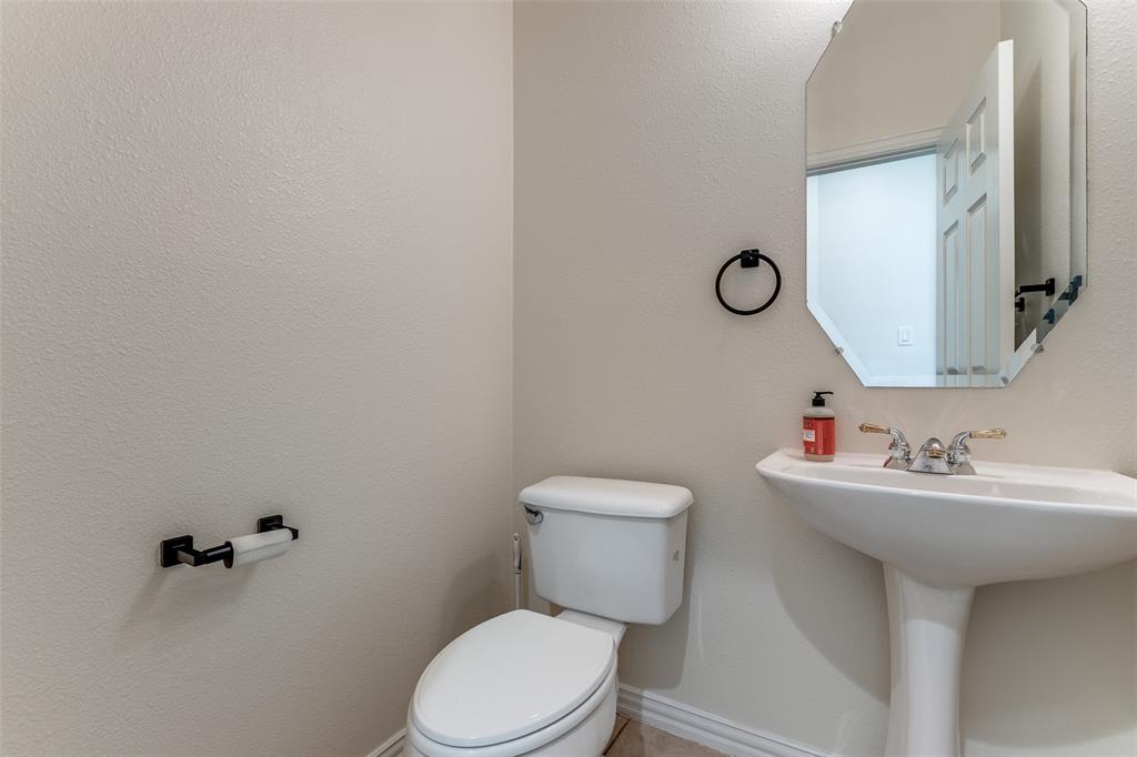 3313 Shady Valley Road Plano, TX 75025 - Photo 28 of 34 a bathroom with a toilet sink and mirror