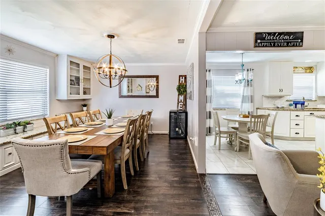 a dining room with furniture a chandelier and wooden floor