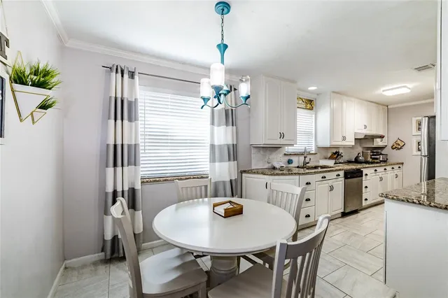 a kitchen with stainless steel appliances kitchen island granite countertop a dining table chairs and granite counter tops