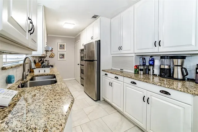 a kitchen with granite countertop a sink stove and refrigerator
