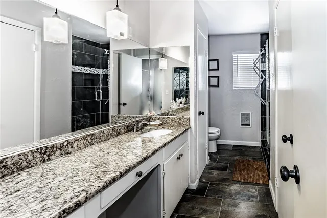 a bathroom with a granite countertop sink mirror and shower