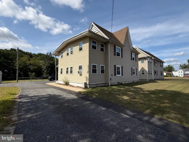 a view of a house with backyard and trees in the background