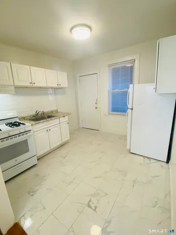 a kitchen with white cabinets and white appliances