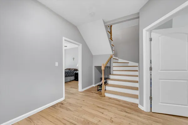 a view of a hallway with wooden floor and entryway
