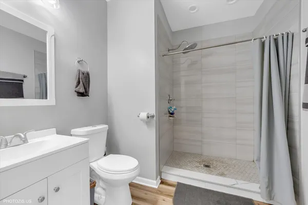 a bathroom with a shower sink vanity and toilet