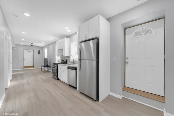 a kitchen with a refrigerator and a stove top oven